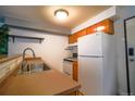 Compact kitchen with white appliances and wood cabinets at 1196 N Grant St # 113, Denver, CO 80203