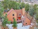 Aerial view of a home with a unique roof design surrounded by lush trees at 23485 Bluestem Dr, Golden, CO 80401