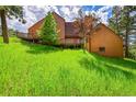 Exterior view of home featuring a large grassy lot and multiple wooden decks with outdoor access at 23485 Bluestem Dr, Golden, CO 80401