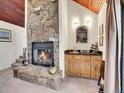 Cozy stone fireplace with a wooden mantle and hearth, complemented by a charming wet bar at 23485 Bluestem Dr, Golden, CO 80401