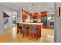 Eat-in kitchen featuring wood cabinets, hardwood floors, granite counters and bar seating at 23485 Bluestem Dr, Golden, CO 80401