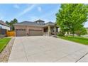 Beautiful brick home with a long driveway and three-car garage, complemented by lush greenery at 1762 Granger Cir, Castle Rock, CO 80109