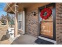Charming front porch with brick accents, decorative wreath and front door at 2986 S Fundy Ct, Aurora, CO 80013