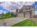 Two-story home featuring stone accents, well-maintained lawn, a three-car garage and landscaped yard at 4864 Harness Ct, Parker, CO 80134