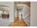 Grand foyer with hardwood floors, staircase with wood railing, and views into the dining room at 4864 Harness Ct, Parker, CO 80134