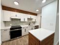 Bright kitchen featuring white cabinetry, stainless steel appliances and a wood accent beam at 2500 S York St # 204, Denver, CO 80210