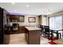 Modern kitchen with stainless steel appliances, center island, and adjacent dining area at 5683 Raleigh Cir, Castle Rock, CO 80104