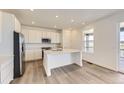 Bright eat-in kitchen featuring stainless steel appliances, white cabinets, and a large kitchen island at 10727 Snowdon St, Parker, CO 80134