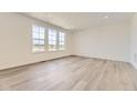 Bright living room featuring hardwood floors, recessed lighting, and large windows offering plenty of natural light at 10727 Snowdon St, Parker, CO 80134