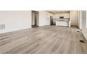 Open floor plan featuring hardwood floors connecting the living and kitchen areas, bathed in natural light at 10727 Snowdon St, Parker, CO 80134