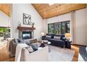 Bright living room with vaulted ceiling, stone fireplace and nature views at 1570 Blakcomb Ct, Evergreen, CO 80439