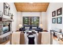 Cozy living room featuring a stone fireplace, wood ceiling and large window views at 1570 Blakcomb Ct, Evergreen, CO 80439