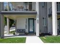 Inviting front entrance with a bench, dark teal door, and a view of the private balcony above at 2197 S Clermont St, Denver, CO 80222