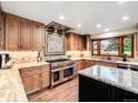 Modern kitchen showcasing wood cabinets, granite countertops, stainless steel appliances, and a center island at 62 N Ranch Rd, Littleton, CO 80127