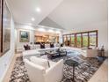 Open-concept living area with fireplace, large sectional, and expansive windows overlooking the outdoor view at 62 N Ranch Rd, Littleton, CO 80127