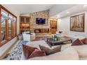 Beautiful living room with stone fireplace, custom cabinets, and cozy seating arrangement at 62 N Ranch Rd, Littleton, CO 80127