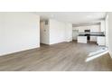 Bright and airy living room featuring wood-look floors and neutral walls, flowing into kitchen at 9293 Biscay St, Commerce City, CO 80022