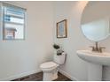 Clean half-bathroom with a pedestal sink, modern fixtures, and decorative accents at 15252 W 69Th Pl, Arvada, CO 80007