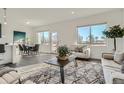 Bright living room with natural light, neutral decor, plush seating, and a view of the outdoors at 15252 W 69Th Pl, Arvada, CO 80007