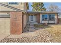 Inviting home entrance with brick accents, manicured landscaping, and a neatly paved walkway at 805 Northridge Rd, Highlands Ranch, CO 80126