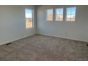 Cozy bedroom with neutral carpet and three windows offering lots of natural light at 2025 Barnwood Dr, Brighton, CO 80601