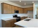 Bright kitchen featuring wooden cabinets, white countertops, stainless steel appliances, and a center island at 2025 Barnwood Dr, Brighton, CO 80601