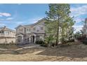 Scenic townhome exterior featuring natural landscaping, mature trees, and neutral paint at 9771 Mayfair St # F, Englewood, CO 80112