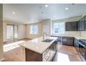 Spacious kitchen featuring an island, dark cabinets, stainless steel appliances, and wood flooring at 23970 E 41St Ave, Aurora, CO 80019