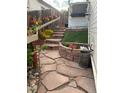 Landscaped backyard with stone steps, retaining wall flower bed, and decorative rock at 8240 Clayton Ct, Denver, CO 80229