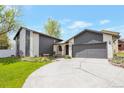Inviting home exterior with a wide driveway, complemented by lush green lawn and tasteful landscaping at 2055 Quail Dr, Lakewood, CO 80215