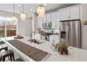 Bright kitchen featuring white cabinets, granite countertops, and stainless-steel appliances at 2591 Iola St, Aurora, CO 80010