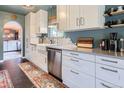 Bright kitchen featuring white cabinets, stainless steel appliances, and stylish backsplash at 6995 W 27Th Ave, Wheat Ridge, CO 80033