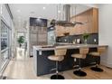 Modern kitchen features an island with bar seating, stainless steel appliances and stylish cabinetry at 512 Cook St, Denver, CO 80206