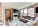 Comfortable living room with fireplace, built-in shelving, and ample natural light at 21302 E Radcliff Pl, Aurora, CO 80015