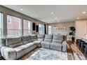 Spacious living room with large windows, modern decor, and wood-look floors at 21302 E Radcliff Pl, Aurora, CO 80015