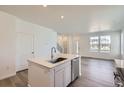 Modern kitchen island featuring a stainless steel dishwasher and faucet at 728 N Bently St, Watkins, CO 80137