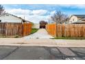 View of the back driveway, featuring an enclosed driveway and open wooden fence at 12116 N Fairfax St, Thornton, CO 80241