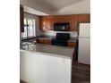 Functional kitchen with granite countertops, wooden cabinets, and modern appliances at 12116 N Fairfax St, Thornton, CO 80241