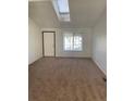 Cozy living room with neutral carpet, bright skylight, and large window allowing natural light at 12116 N Fairfax St, Thornton, CO 80241