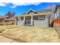 Beautiful craftsman home with a stone facade and inviting front porch, set against a blue sky backdrop at 2827 Bellaire St, Denver, CO 80207