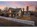 Home with a white picket fence, lush lawn, and a detached garage at sunset at 1433 Olive St, Denver, CO 80220