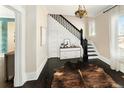 Inviting foyer featuring dark wood floors, staircase, and a stylish cowhide rug at 1433 Olive St, Denver, CO 80220