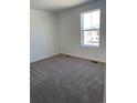 Bright, carpeted bedroom with a large window providing ample natural light, ready for personalization and comfort at 21966 E 39Th Pl, Aurora, CO 80019