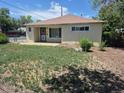 Charming single-story home with quaint front yard with a concrete porch and a secure front door at 1303 Havana St, Aurora, CO 80010