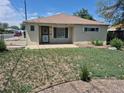 Charming single-story home with quaint front yard with a concrete porch and a secure front door at 1303 Havana St, Aurora, CO 80010