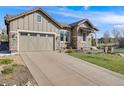 Two-car garage with a long driveway offering ample parking, complemented by a well-maintained lawn and landscaping at 360 Basilwood Way, Highlands Ranch, CO 80126
