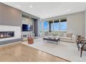 Bright living room features a modern fireplace, large windows with scenic views, and stylish furniture at 9395 Night Star Pl, Lone Tree, CO 80124