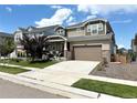 Charming two-story home featuring a well-kept lawn and a spacious driveway leading to a two-car garage at 17955 E 107Th Pl, Commerce City, CO 80022