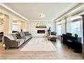 Bright living room featuring a fireplace, elegant decor, and large windows with sheer curtains at 17955 E 107Th Pl, Commerce City, CO 80022
