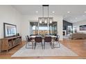 Bright dining room with hardwood floors, stylish light fixture, and sliding glass doors to the outdoor space at 751 Green Mountain Dr, Erie, CO 80516